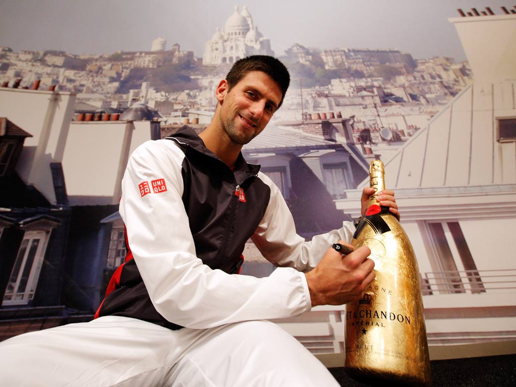 Novak Djokovic signs the bottle