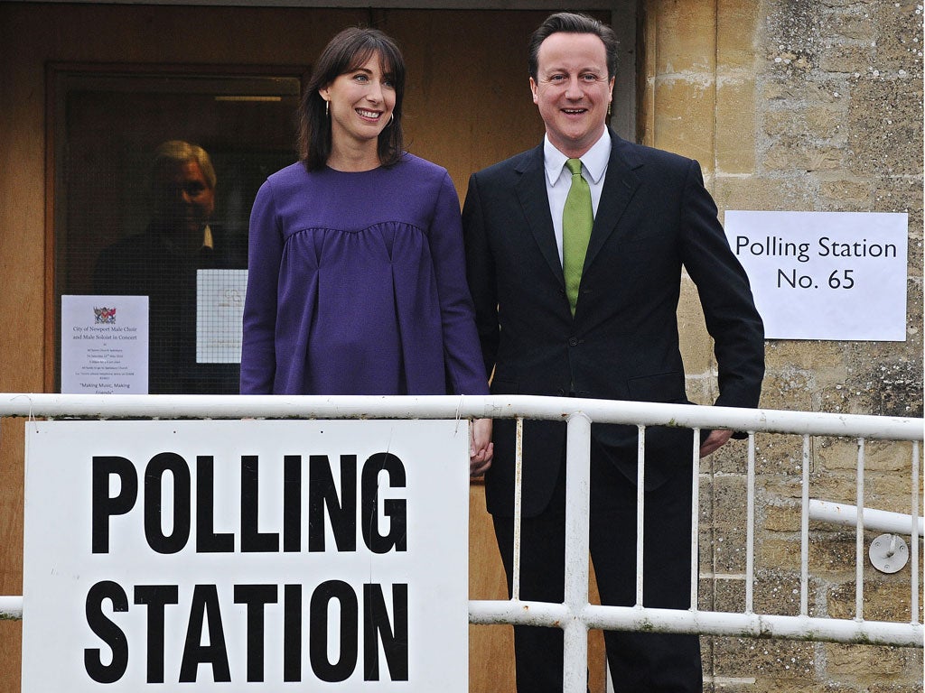 David Cameron (R) and wife Samantha leave after voting at a polling station in Spelsbury, Oxfordshire, on May 6, 2010