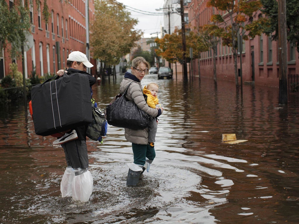 A family navigate a flooded street in Hoboken, New Jersey, where many vulnerable residents are trapped in tower blocks