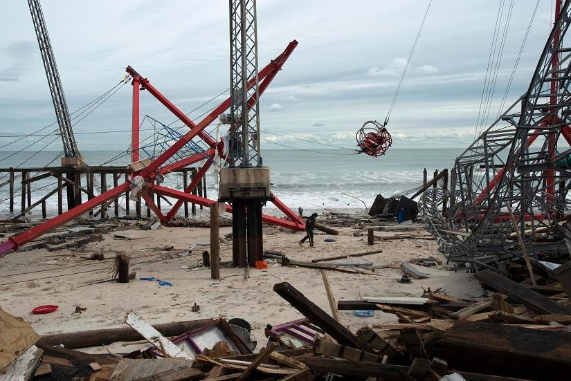 STORM SEASIDE: A police officer walks through the debris of the Funtown Pier in Seaside Heights, N.J., on Thursday. The pier and amusement park was destroyed by Hurricane Sandy.
