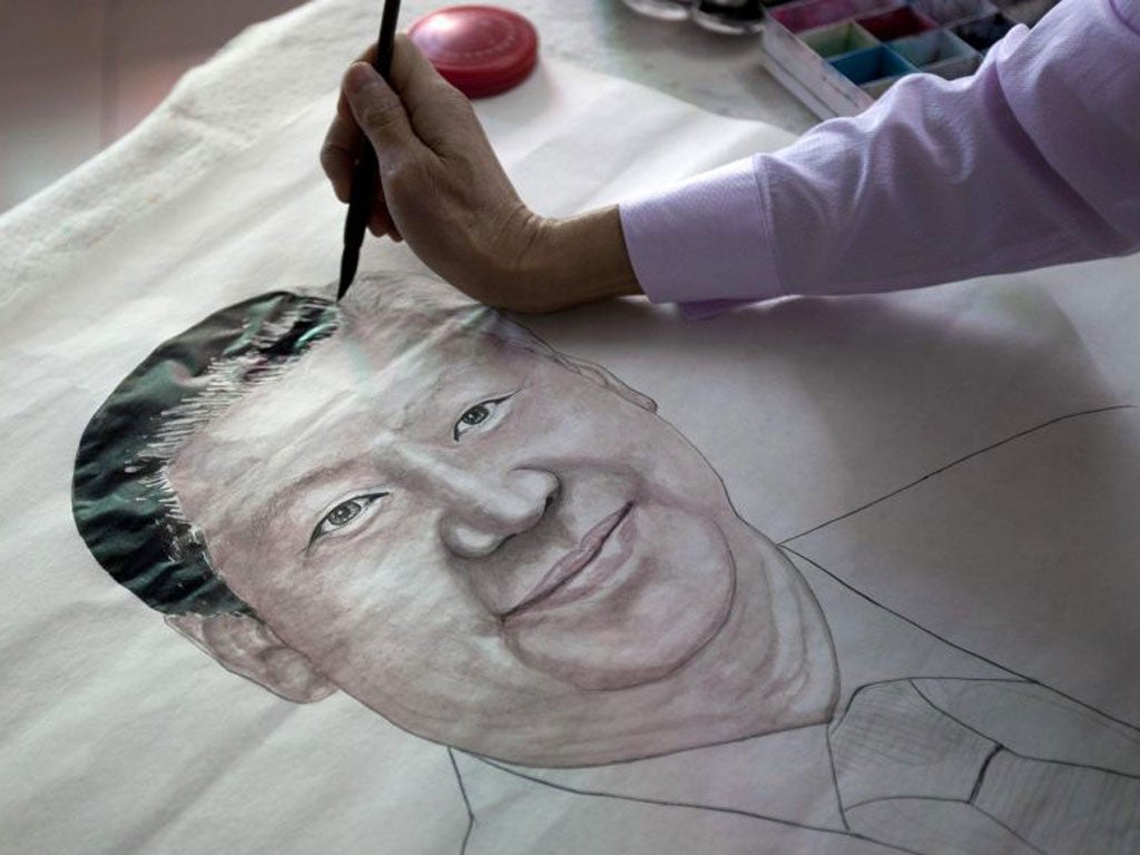 Artist Luo Jianhui draws a portrait of China’s President-elect, Xi Jinping, in his studio in Guangzhou