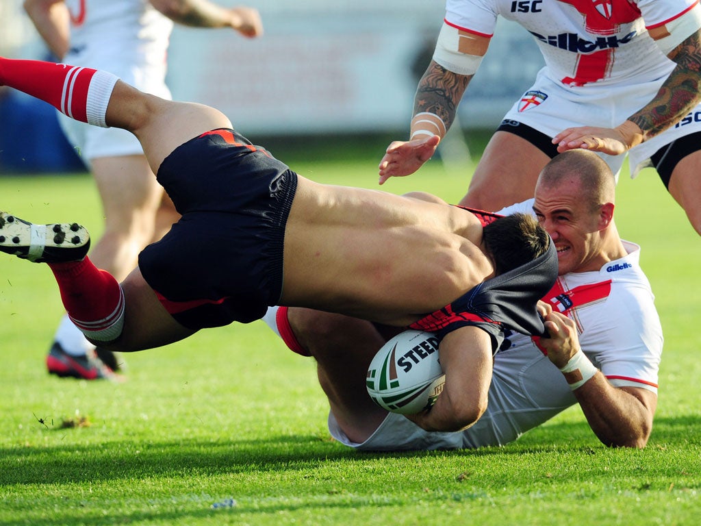 Getting shirty: France centre Damien Cardace almost loses his jersey as he is tackled by England forward Lee Mossop