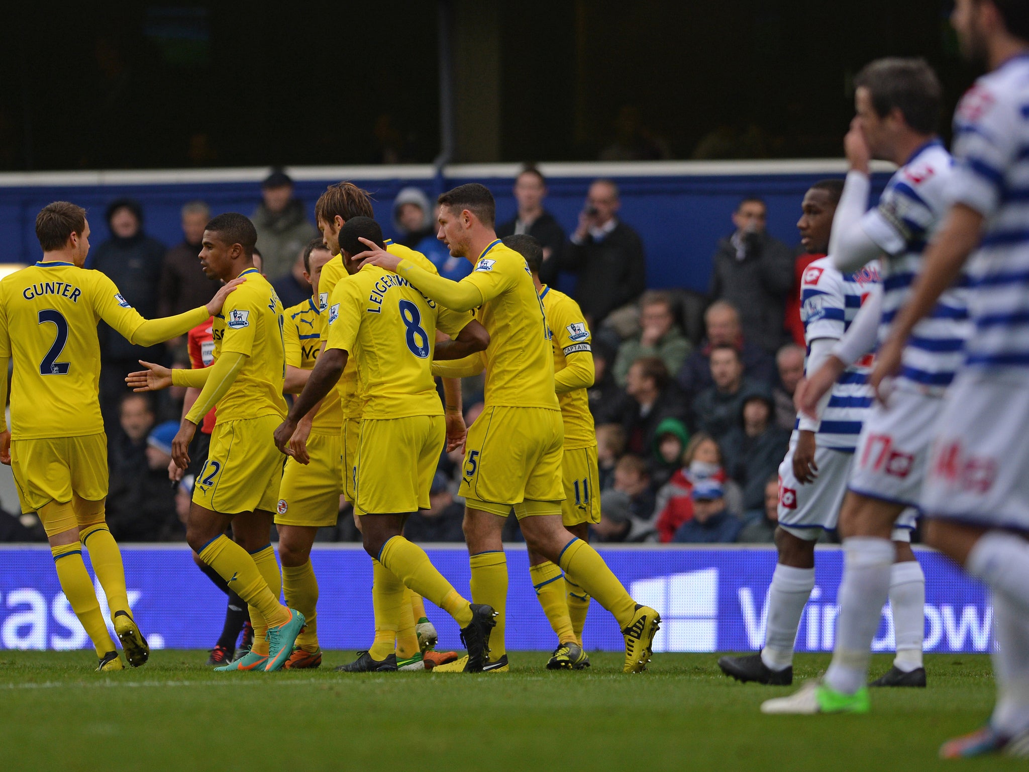 The Reading players celebrate their goal as QPR look on