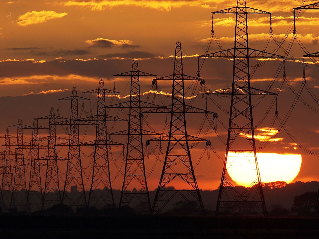The sun sets behind power lines running from Dungerness nuclear power station on July 25, 2009 near Lydd, United Kingdom.
