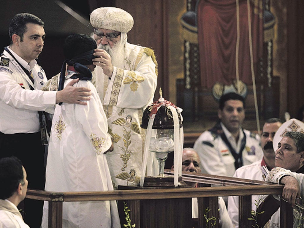 The acting Coptic Pope, Bishop Pachomius, blindfolds Bishoy
Massad, the eight-year-old selected to draw the name of the next patriarch at St Mark’s Cathedral in Cairo