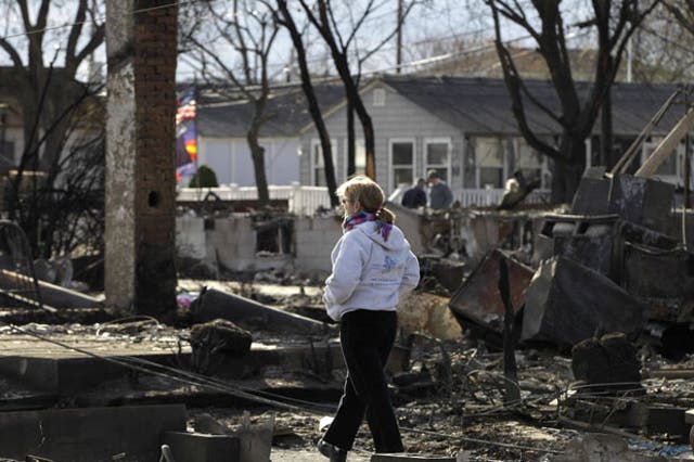 A woman walks through an area impacted by Superstorm Sandy in Breezy Point