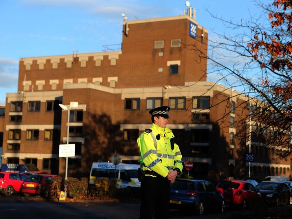 A police officer stands at the entrance to Baird Street Police Station in Glasgow following the death of a police officer