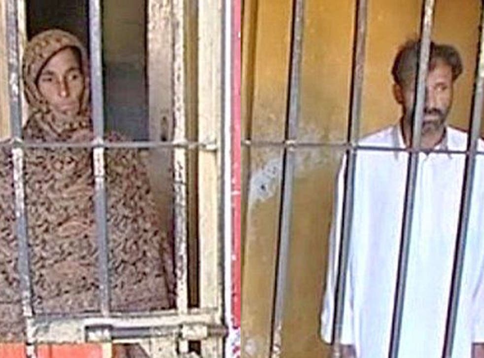 Muhammad Zafar, right, and his wife Zaheen behind bars