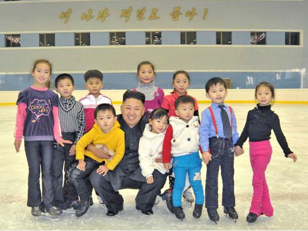 North Korean leader Kim Jong Un posing with children as he visits the open air ice skating rink in Pyongyang