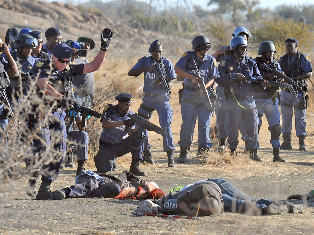 Police surround the bodies of victims killed in the clashes at Marikana in August