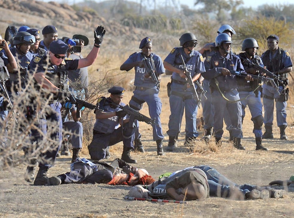 Police surround the bodies of victims killed in the clashes at Marikana in August