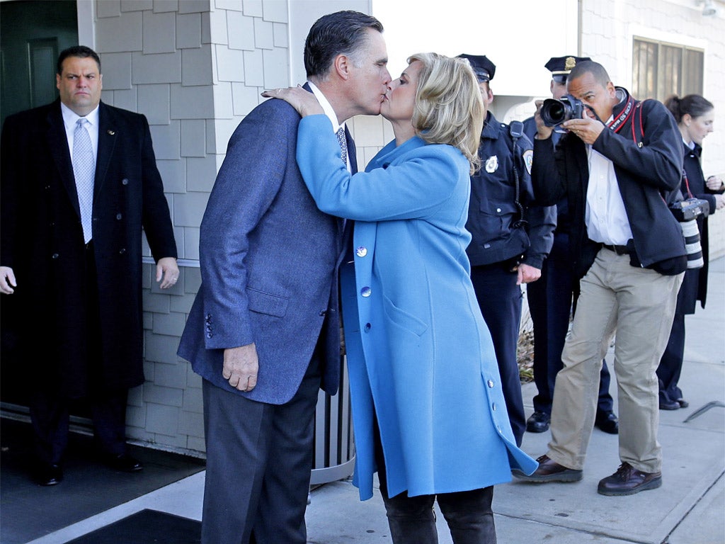 Mitt Romney and his wife Ann pose for the cameras before voting in Boston, Massachusetts