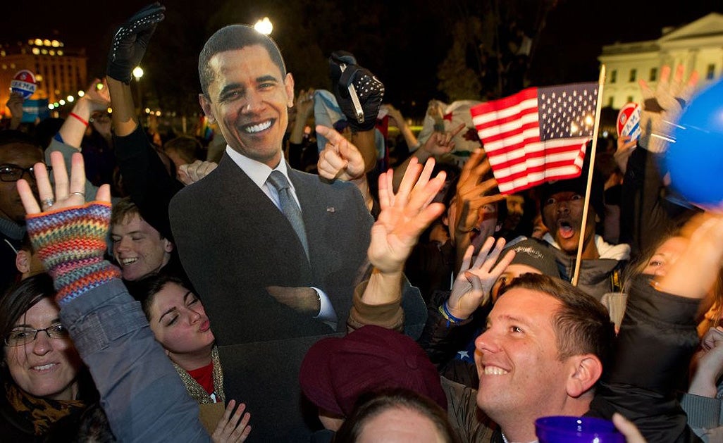 People celebrate in front of the White House with a cardboard cut-out of the President