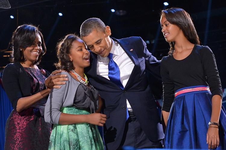 US President Barack Obama celebrates on stage with his daughters Sasha (2nd L) and Malia (R) and his wife Michelle
