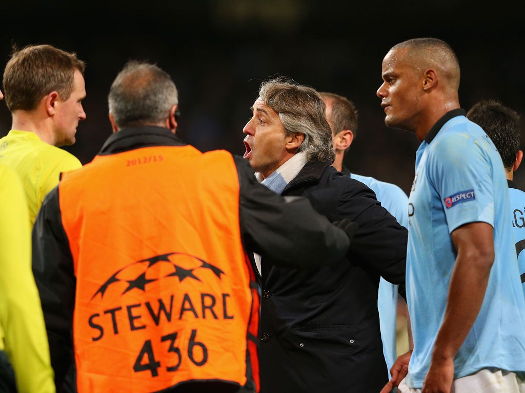 Manchester City Manager Roberto Mancini protests to Referee Peter Rasmussen after he denied his team a penalty