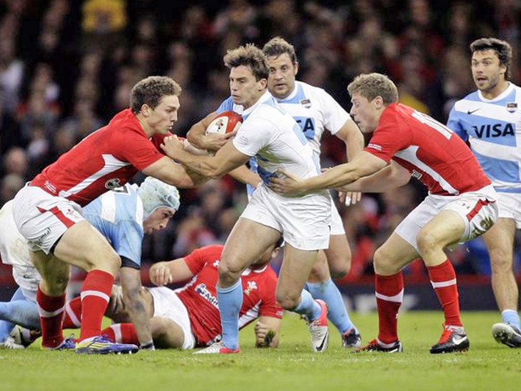 Argentina's Juan Imhoff, centre, attempts to break past Wales's George North, left, and Rhys Priestland, second right