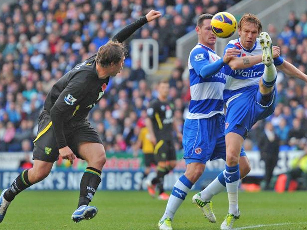 Reading's Latvian defender Kaspars Gorkss, right, clears the ball during the English Premier League football match against Norwich City at The Madejski Stadium