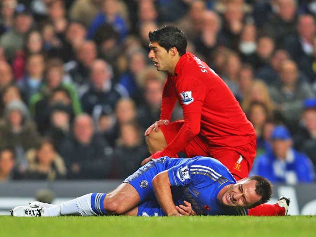 John Terry of Chelsea is injured in a collision with Luis Suarez of Liverpool during the Barclays Premier League match