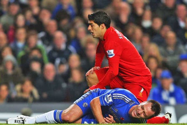 John Terry of Chelsea is injured in a collision with Luis Suarez of Liverpool during the Barclays Premier League match