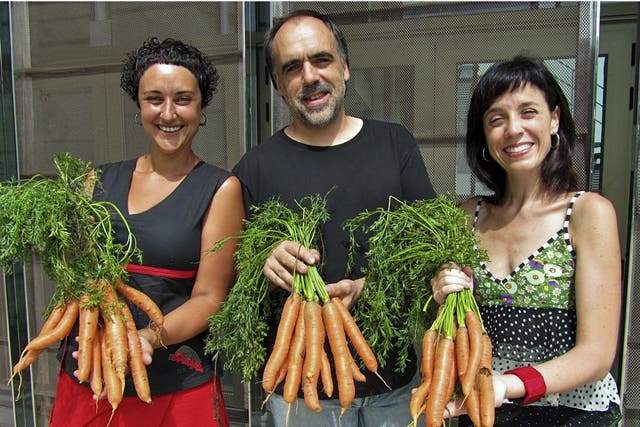 At a municipal theater in north eastern Spain, director Quim Marce (center) and actresses Meritxell Yanes (left) and Elena Martinell (right) display carrots for sale