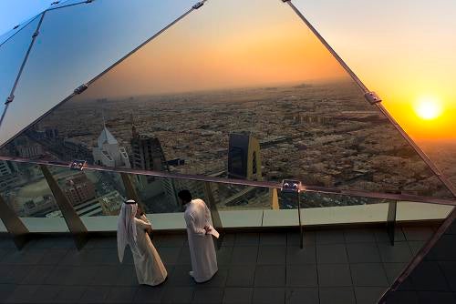 Saudi men reflected in the mirrors of the Al-Faisaliyah Center viewing level which overlooks the expansive city of Riyadh, Saudi Arabia