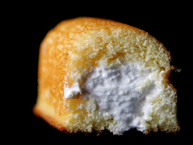 Part of a Hostess Twinkie golden sponge cake with its creamy filling exposed