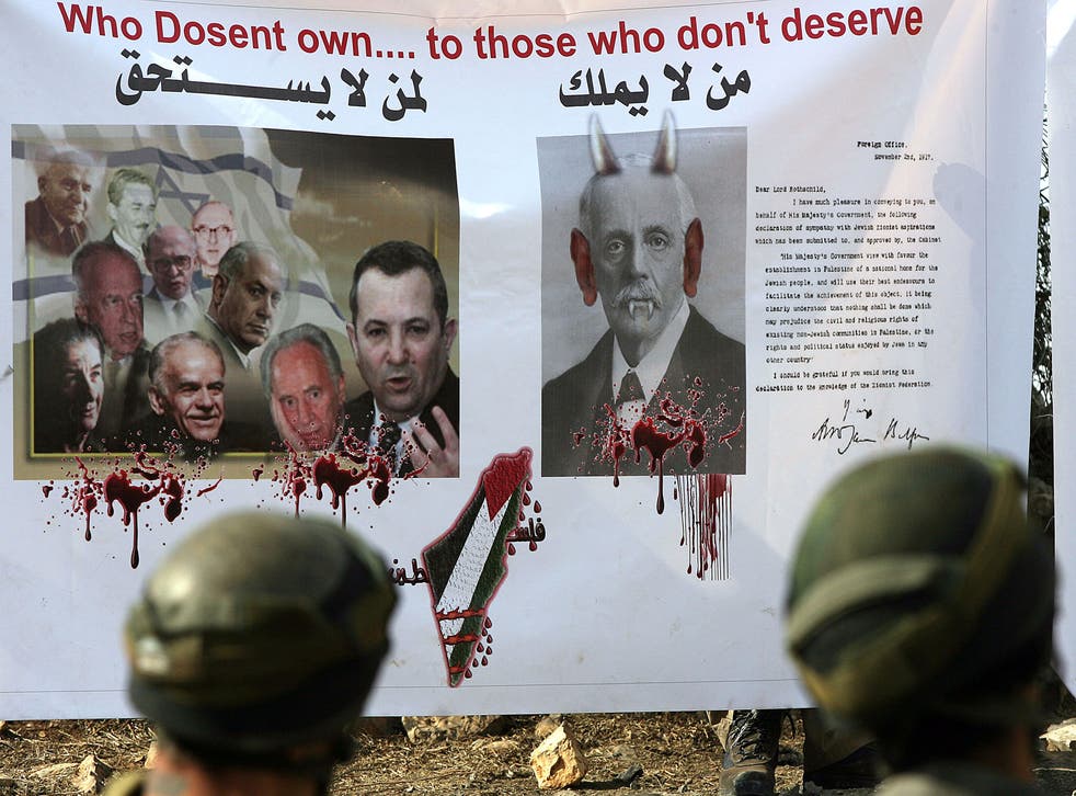 Israeli soldiers stand in front of a banner with a copy of a letter from the British Foreign Secretary Arthur James Balfour to Baron Rothschild (a leader of the British Jewish community) known as the Balfour Declaration of 1917, as Palestinians, Israeli and foreign protesters demonstrate in the Israeli-occupied West Bank on November 06, 2010.