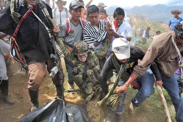 Indigenous Colombians drag a soldier from a military post on Mount Berlin. They expelled troops from the area after harassment by Farc guerrillas