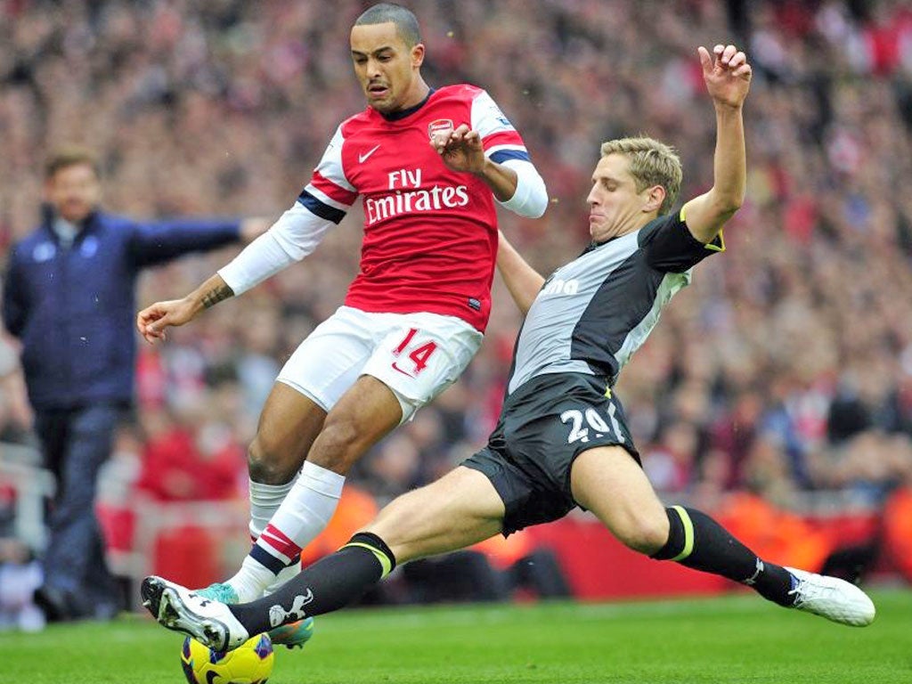 Theo Walcott is challenged by Spurs’ Michael Dawson