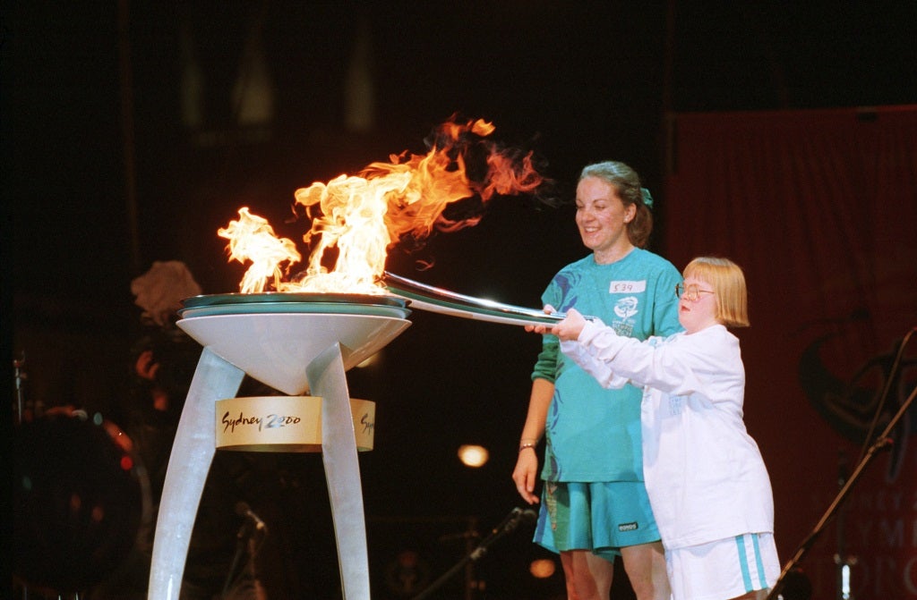Therese Garton, who has Down's syndrome and is a Special Olympian, lights the Olympic cauldron in Victoria Square, Adelaide, Australia. With her is her mother, Bev.