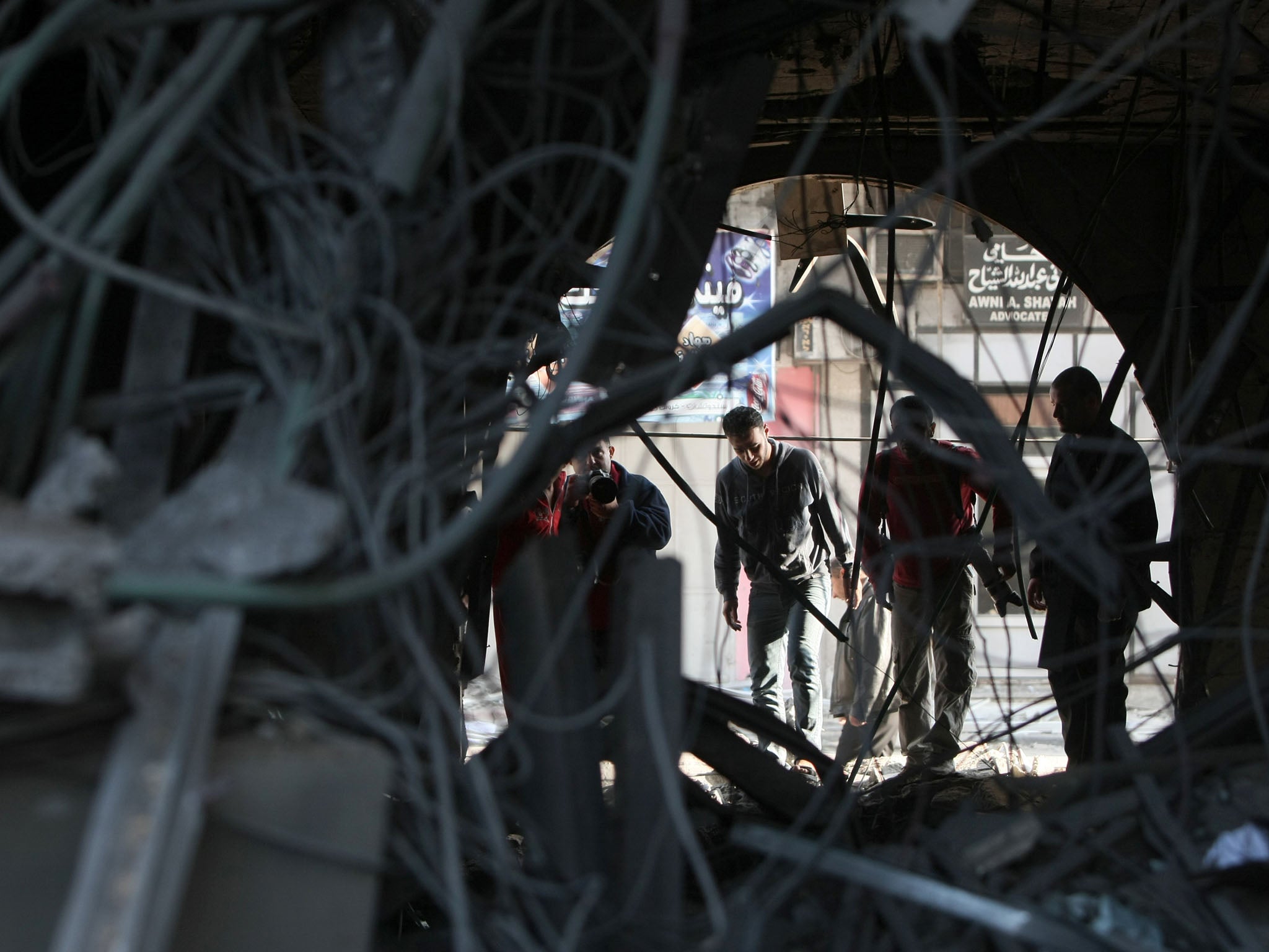 Palestinians inspect damage from an Israeli air strike