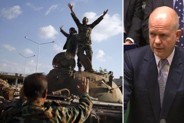 Syrian rebels celebrate the victory on top of a tank they took after storming a military base in Aleppo yesterday. William Hague, left, said the UK recognised the rebels as the 'sole legitimate representative' of the Syrian people today