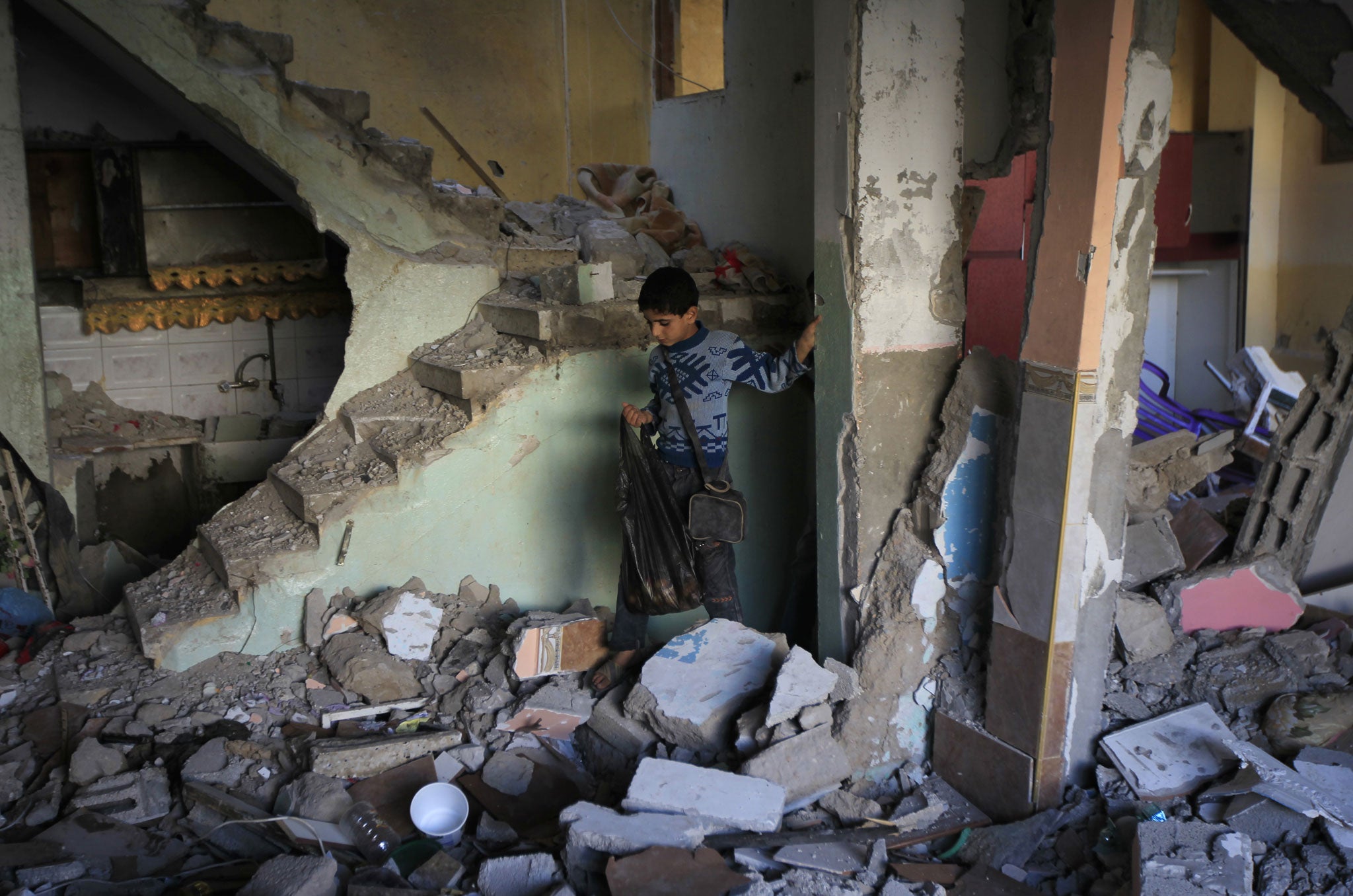 A Palestinian boy walks through the rubble inside the house of Hamas commander Raed al-Attar which was targeted by an overnight Israeli air strike in the southern Gaza Strip town of Rafah on November 20, 2012.