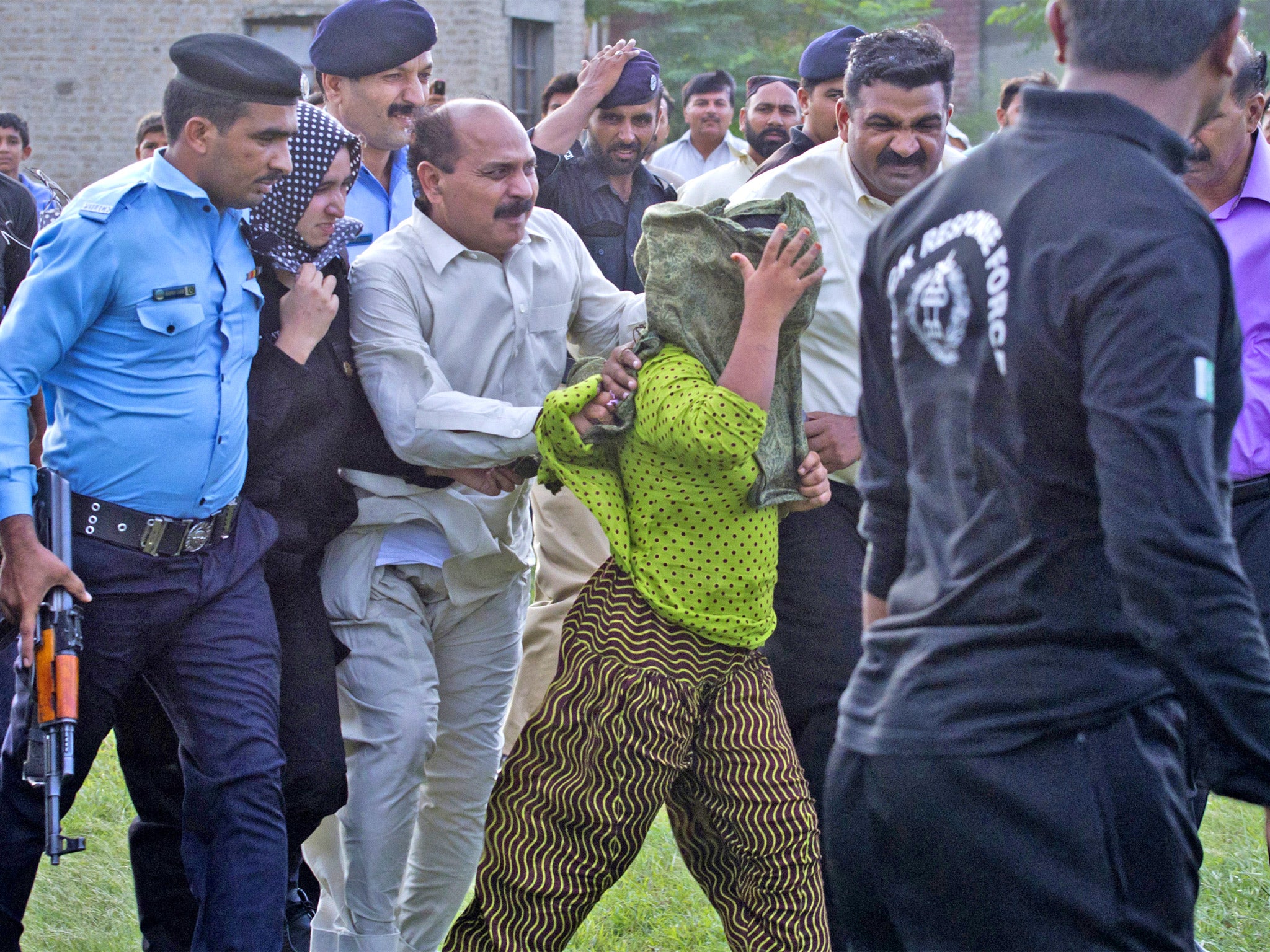 Officials escort Rimsha Masih to a helicopter after her release in September