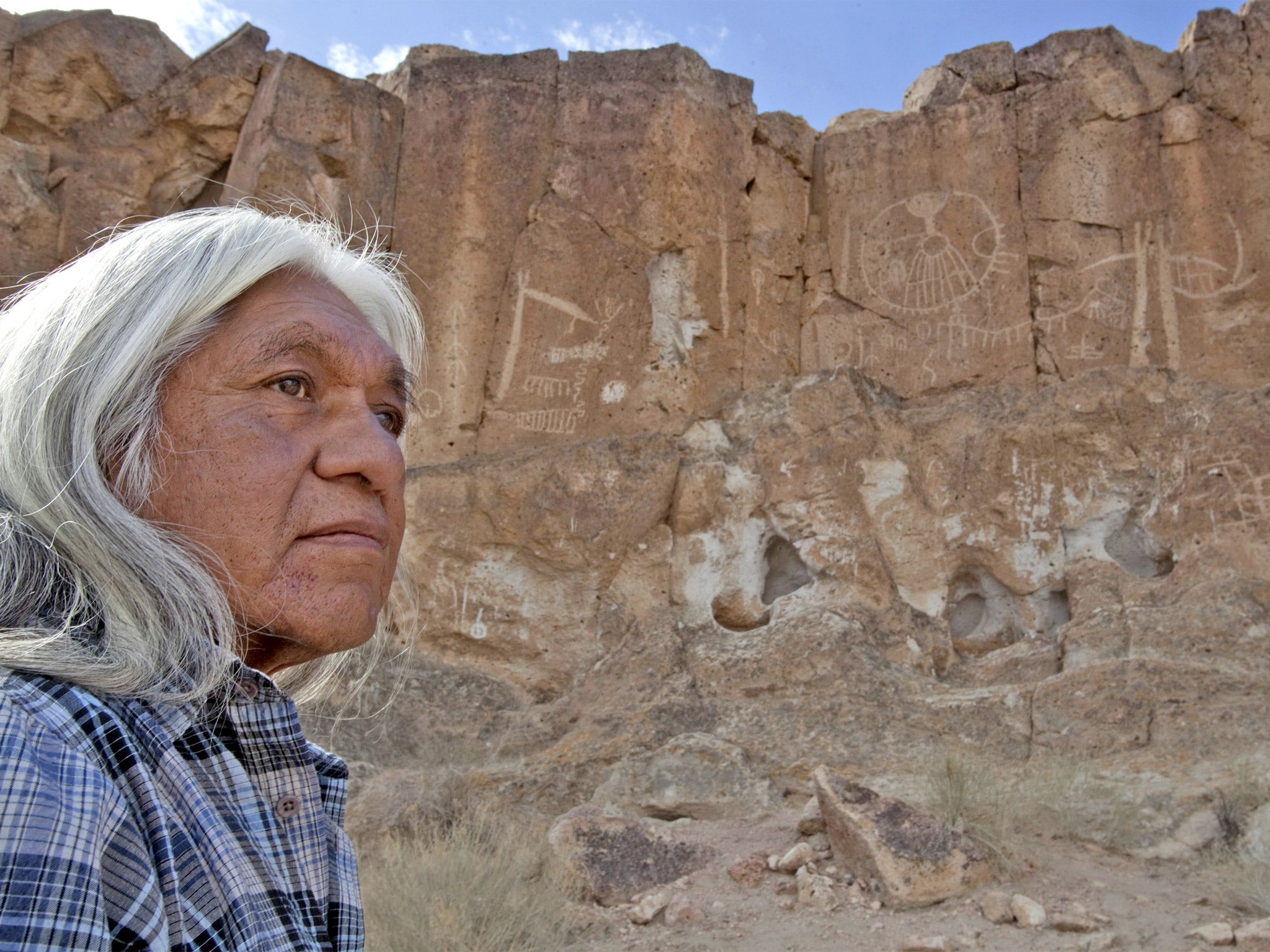 Raymond Andrews, the local tribal historical preservation officer, examines the damage