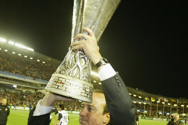 Rafael Benitez celebrates with the Uefa Cup after Valencia beat Marseille