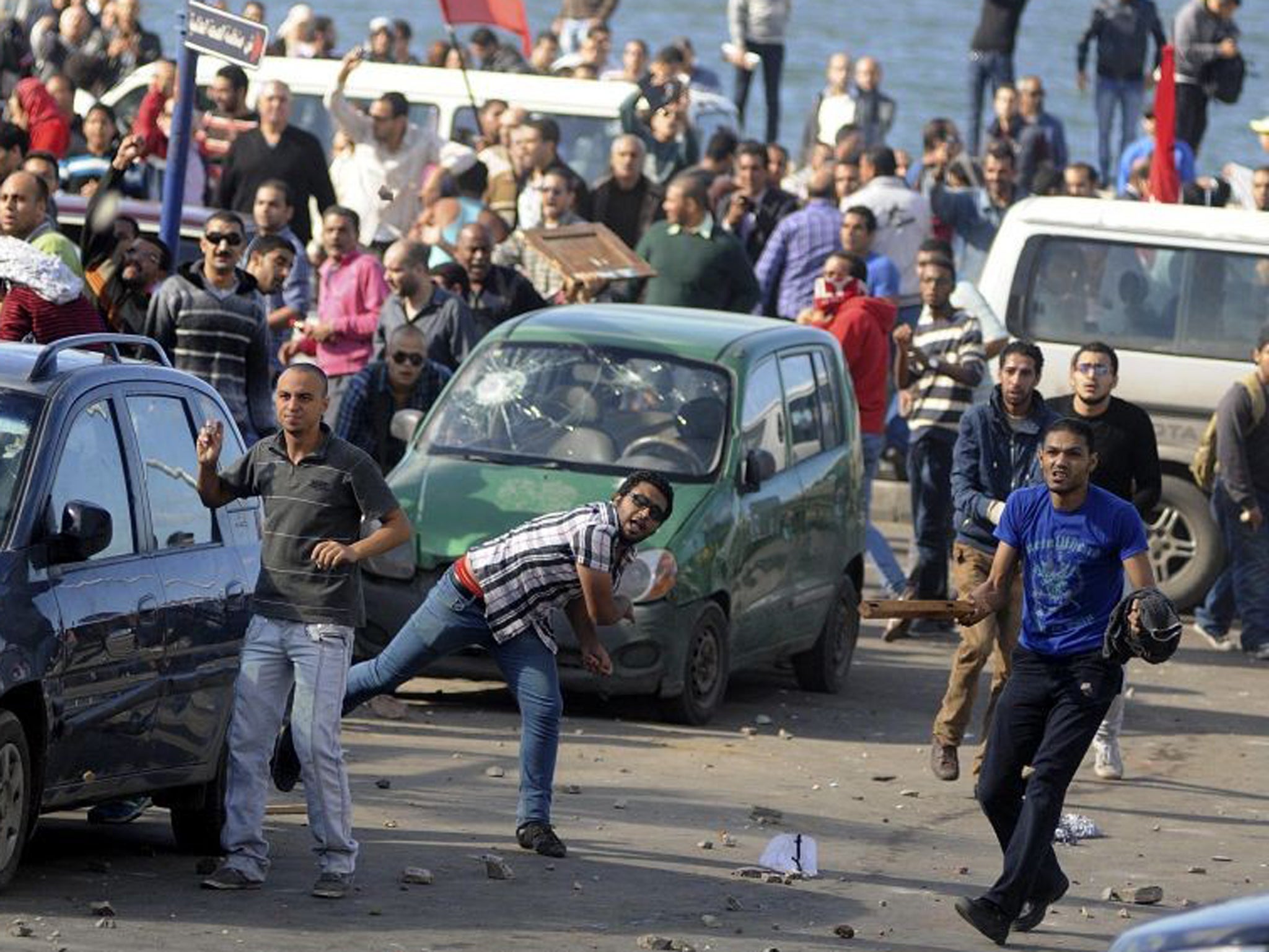 Protesters hurl stones during clashes between supporters and opponents of Mohammed Morsi in Alexandria
