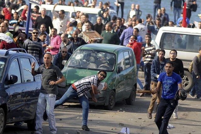 Protesters hurl stones during clashes between supporters and opponents of Mohammed Morsi in Alexandria