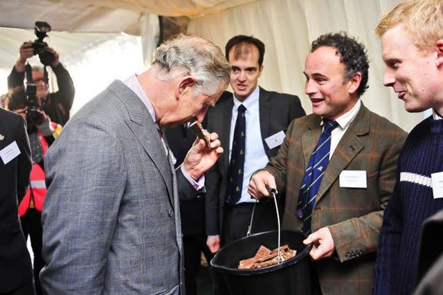 The Prince of Wales smells waste chocolate used in an anaerobic digester during a visit to Dorset this week