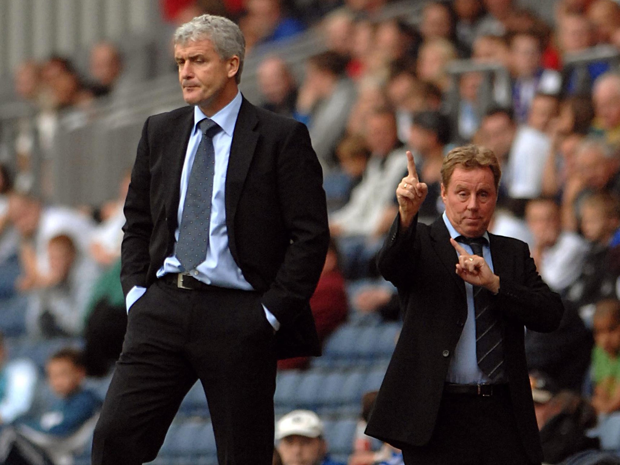 Harry Redknapp points the way ahead behind the back of Mark Hughes