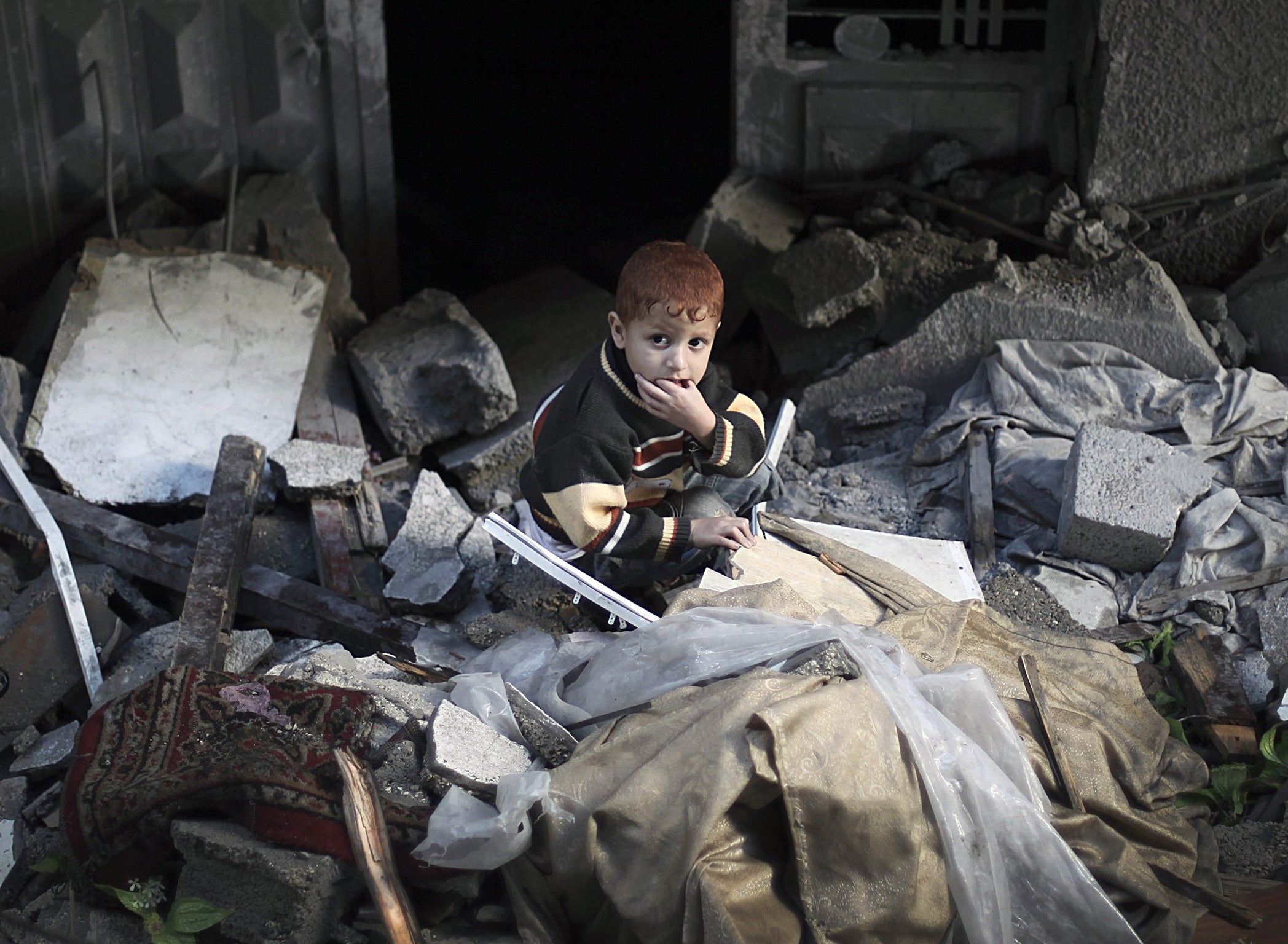 Destruction: A boy sits in a Gaza house wrecked by an Israeli air-strike