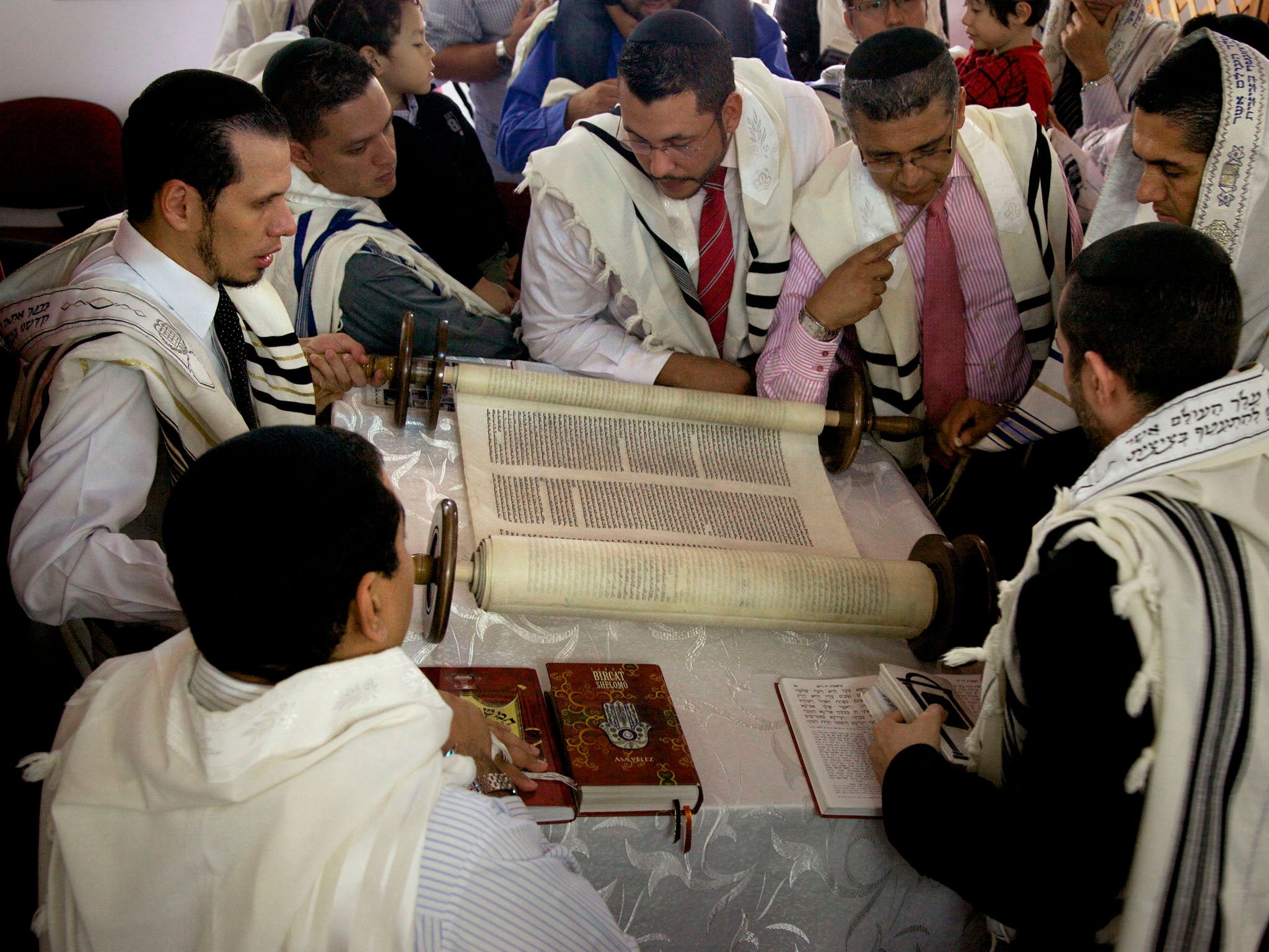 COLOMBIA: Members of the Jewish congregation in Bello, Colombia gather round a 120-year-old Torah scroll written in Amsterdam and obtained by the community five years ago.