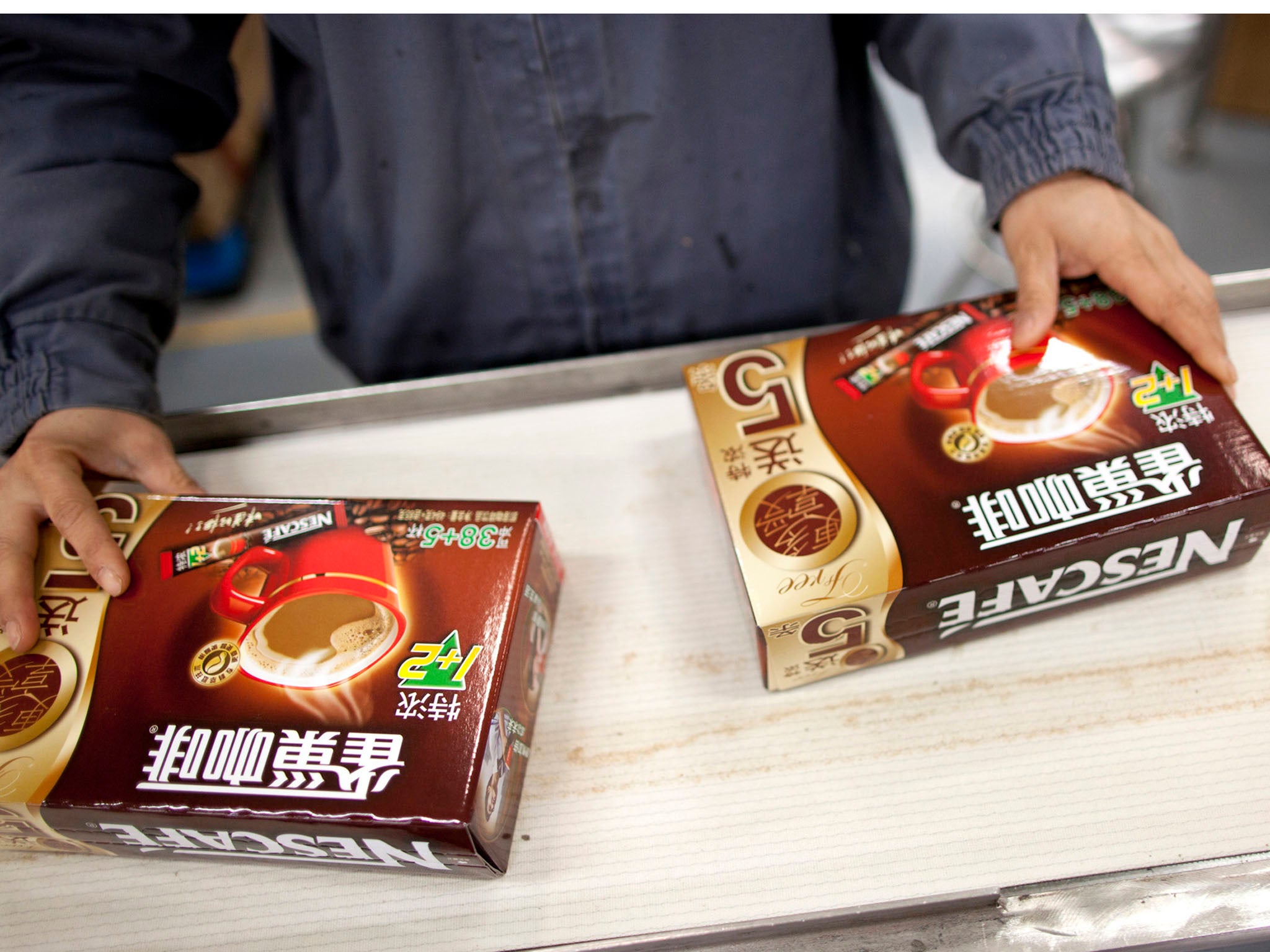 NESTLE CHINA: A worker packages Nescafe at Nestle's production facility in Dongguan, China. After peddling Nescafe and other products in China, the Swiss company is now asking Chinese consumers what they really want.
