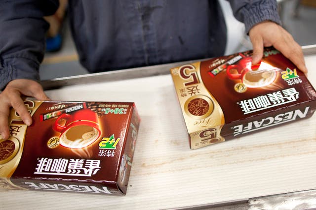 NESTLE CHINA: A worker packages Nescafe at Nestle's production facility in Dongguan, China. After peddling Nescafe and other products in China, the Swiss company is now asking Chinese consumers what they really want.