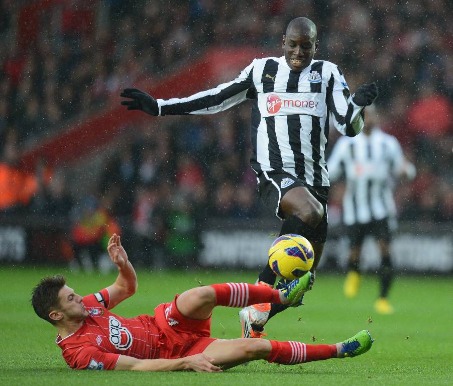 Demba Ba of Newcastle is challenged by Adam Lallana of Southampton