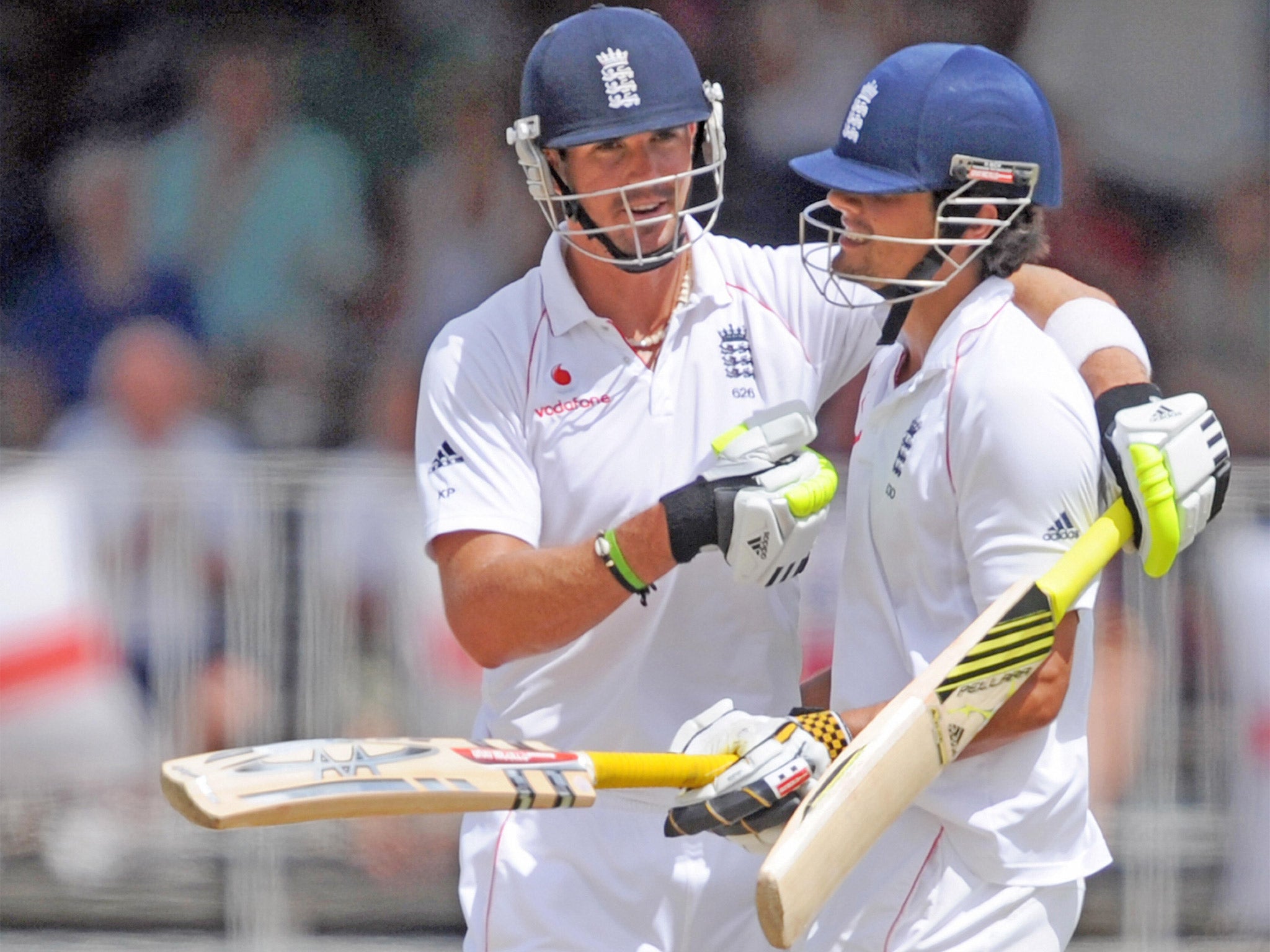 England's cricketer Kevin Pietersen (L) congratulates his teammate Alastair Cook