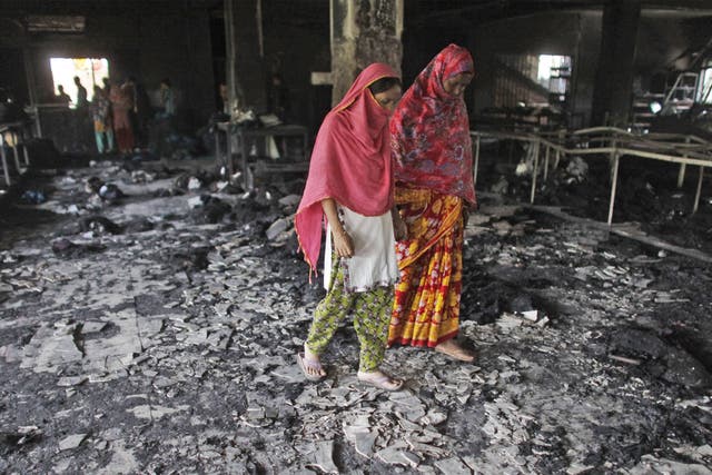 Workers return to the site of the burnt-out nine-storey garment factory where more than 100 people died