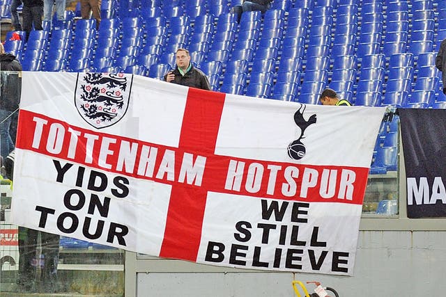 A section of Spurs fans rally behind a controversial banner