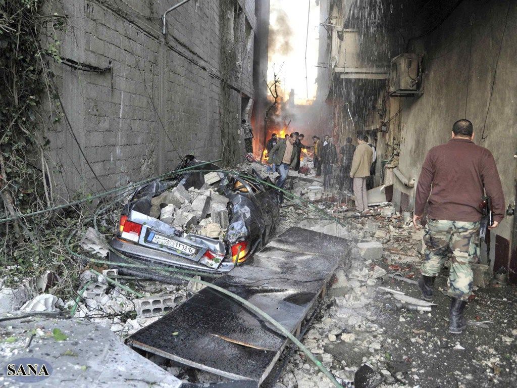 Twin car bombs have ripped through a Damascus suburb killing and wounding dozens of people