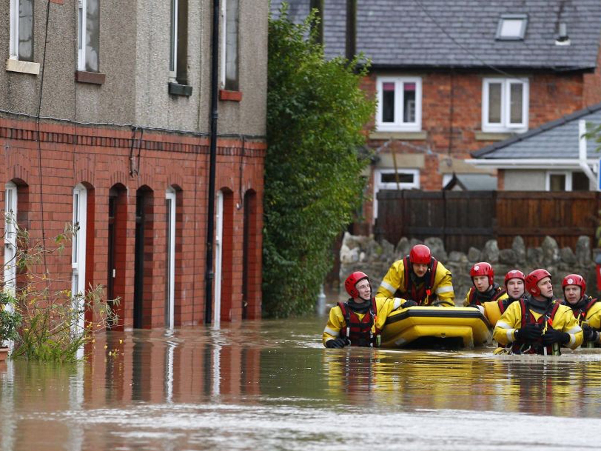 A crew from the North Wales Fire and Rescue service help a resident to safety in St. Asaph, Denbighshire, North Wales